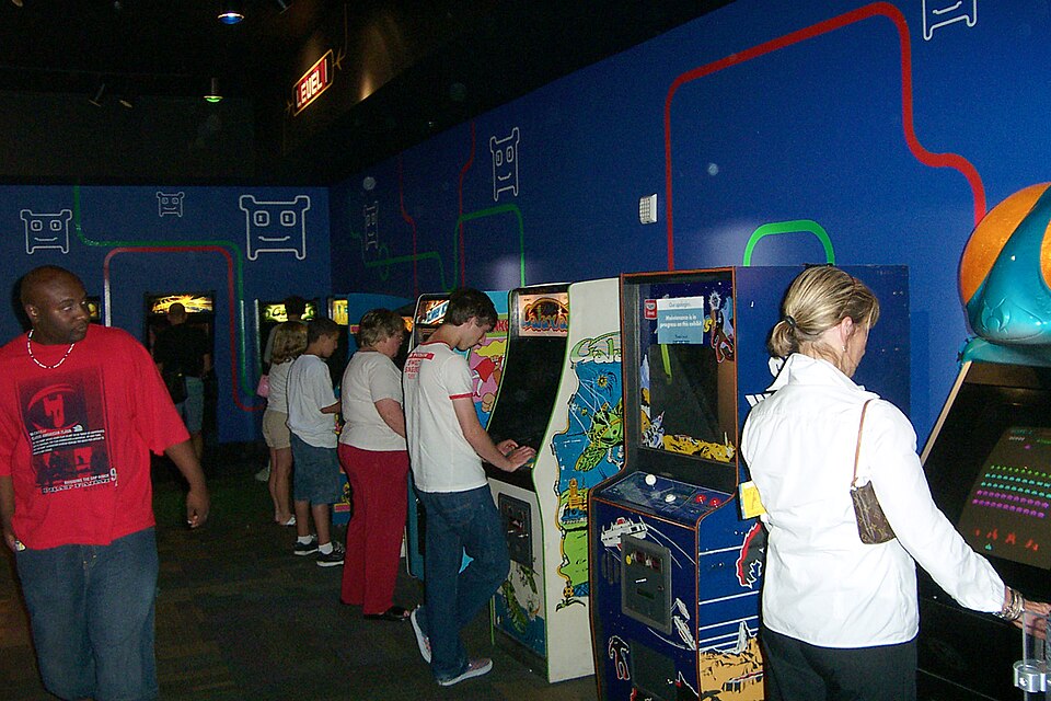 People play on video game arcade cabinets.