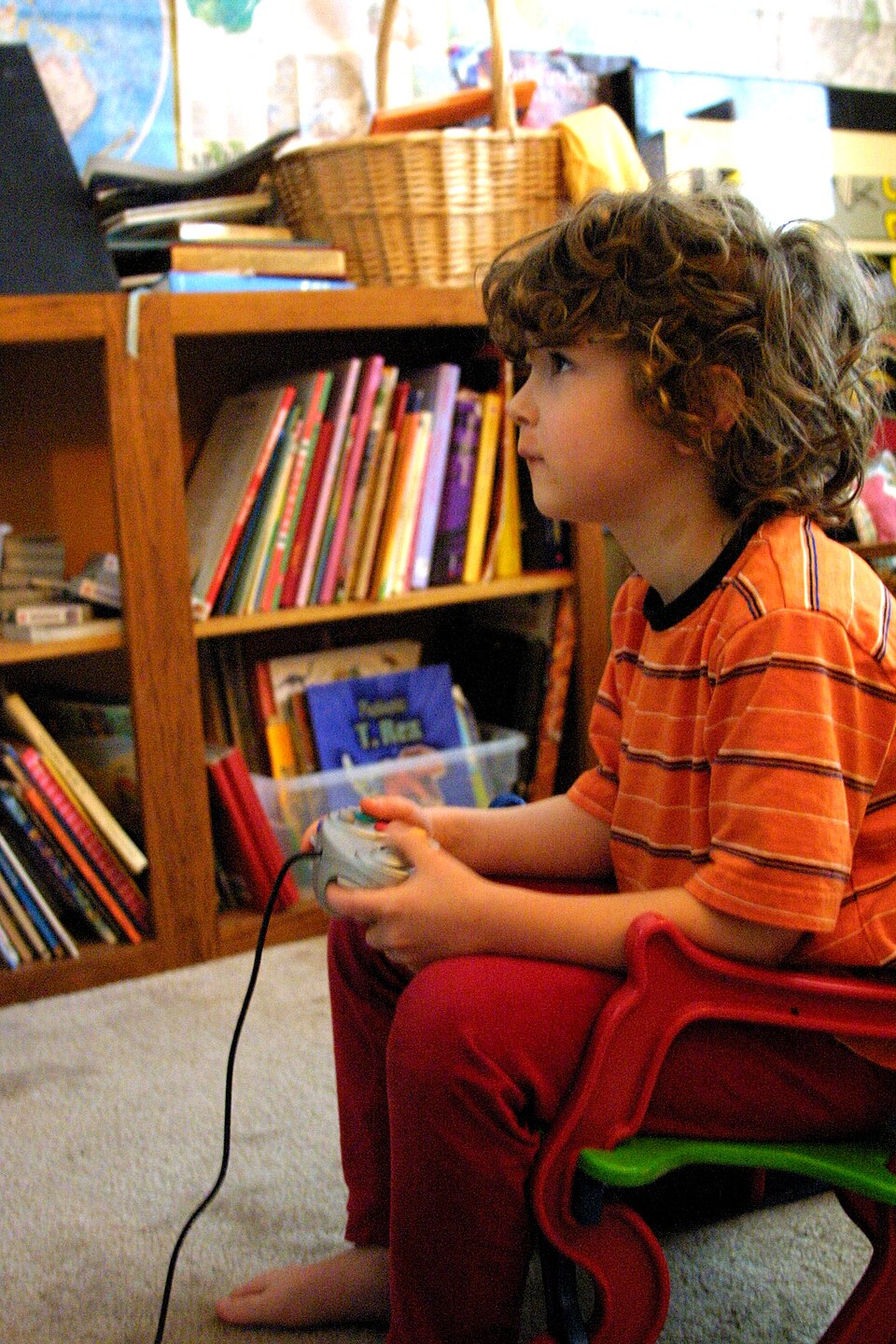A kid plays a video game on a GameCube video game console.