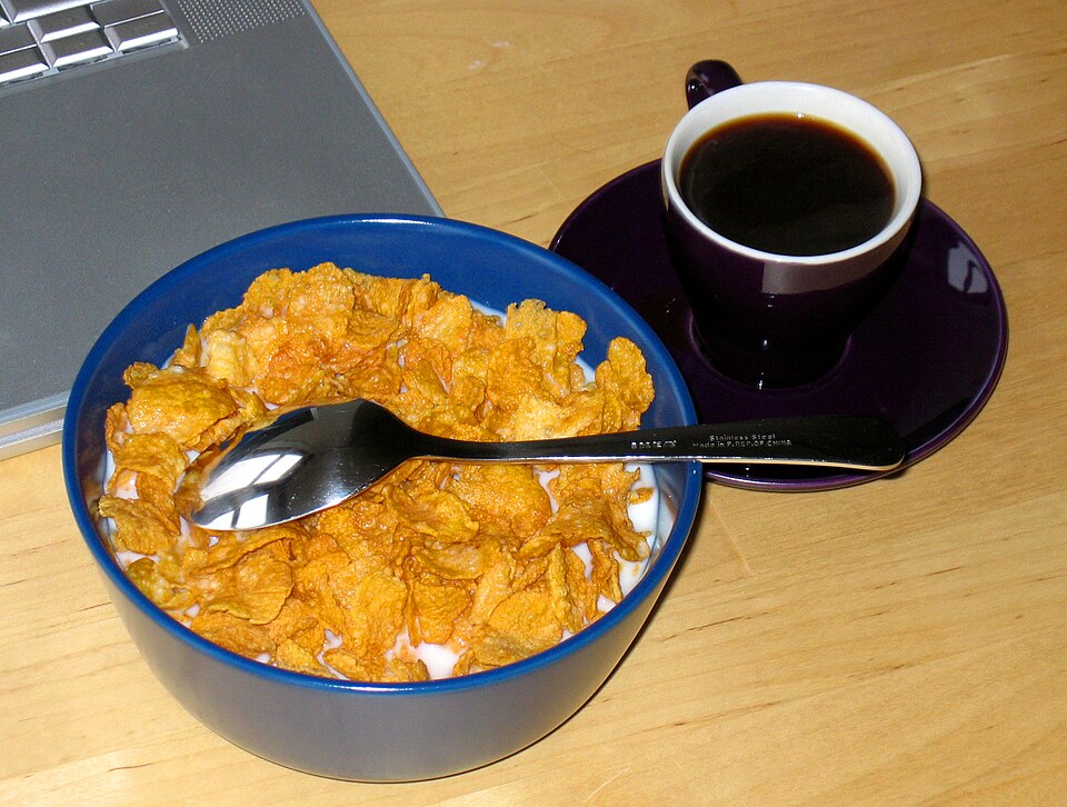 A bowl of breakfast cereal with a cup of coffee.
