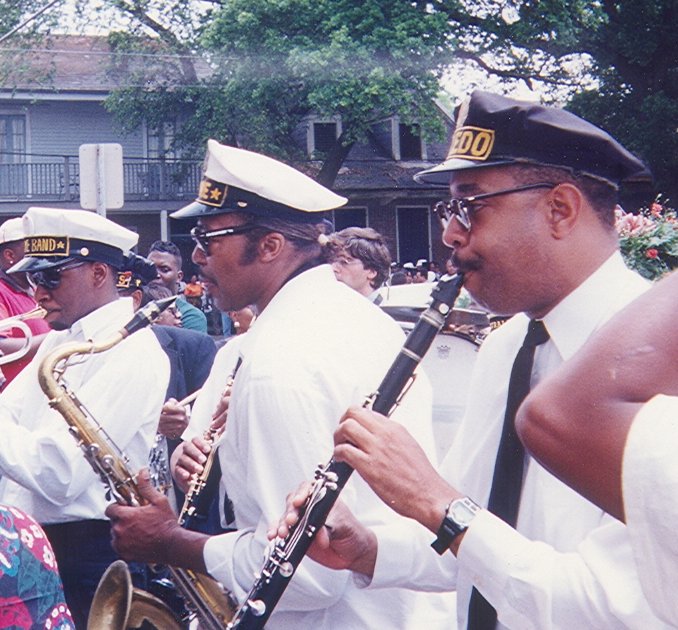 Clarinet being played by a marching band. Surrounding the clarinetist are other instruments, such as a saxophone.