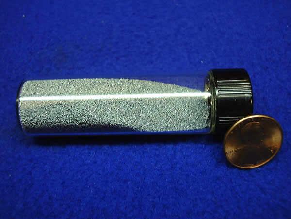 Granules of tungsten in a glass vial.