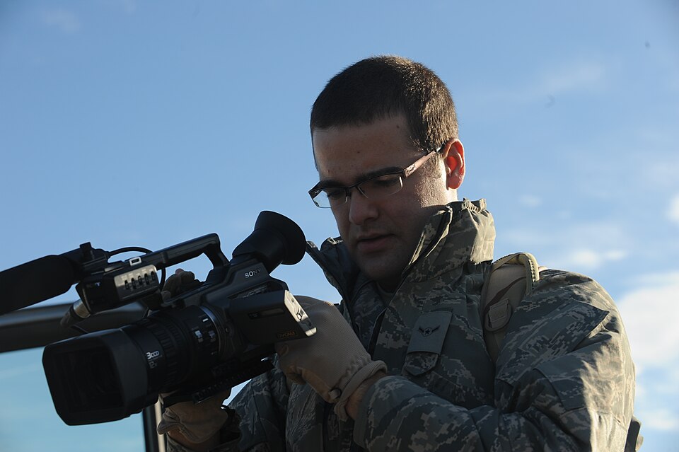 {{center|Cameraman checks his video camera before shooting}}