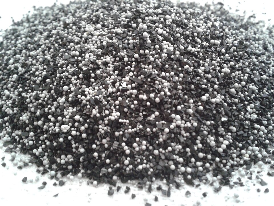 The contents of a domestic water filter. The black objects are activated carbon. The white objects are ion-exchange resin.