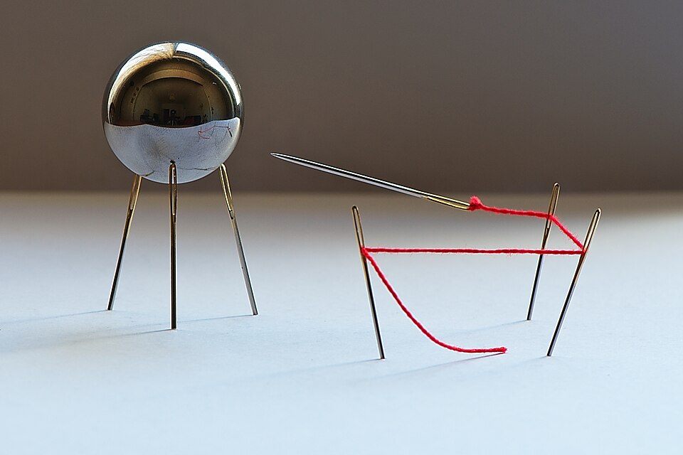 A magnetized needle is floating in the air next to a metal ball